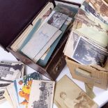 A briefcase full of early 20th century postcards, and a box of loose early postcards and photographs