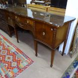 A Regency style mahogany serpentine-front sideboard, fitted drawers and cupboards, on square tapered