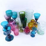 A group of coloured glass drinking glasses, beakers, vases etc