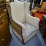 An Antique wingback fireside chair, on bun feet (for re-upholstering)