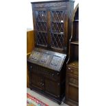 An oak 2-section bureau bookcase with lead-light glazed doors, with a linenfold fall-front, and
