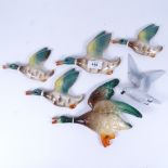A group of graduated pottery wall-hanging flying ducks, largest length 24cm, and a German pottery