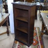 A 1920s oak narrow open bookcase with chip carved decoration, W55cm, H110cm, D26cm