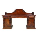 Victorian mahogany twin pedestal sideboard, circa 1870, having a carved panel back centred with a