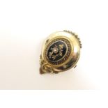 Victorian yellow metal brooch, circa 1880, slight oval form with raised black enamelled centre