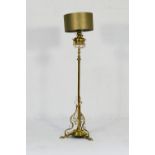 Late Victorian brass standard lamp, having a brass tank over an extendable column, the base with
