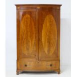 Edwardian mahogany and inlaid bow front wardrobe, having a dentil cornice with a shell inlaid frieze