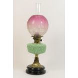 Victorian pedestal oil lamp, having a cranberry tinted and etched globular shade over a moulded