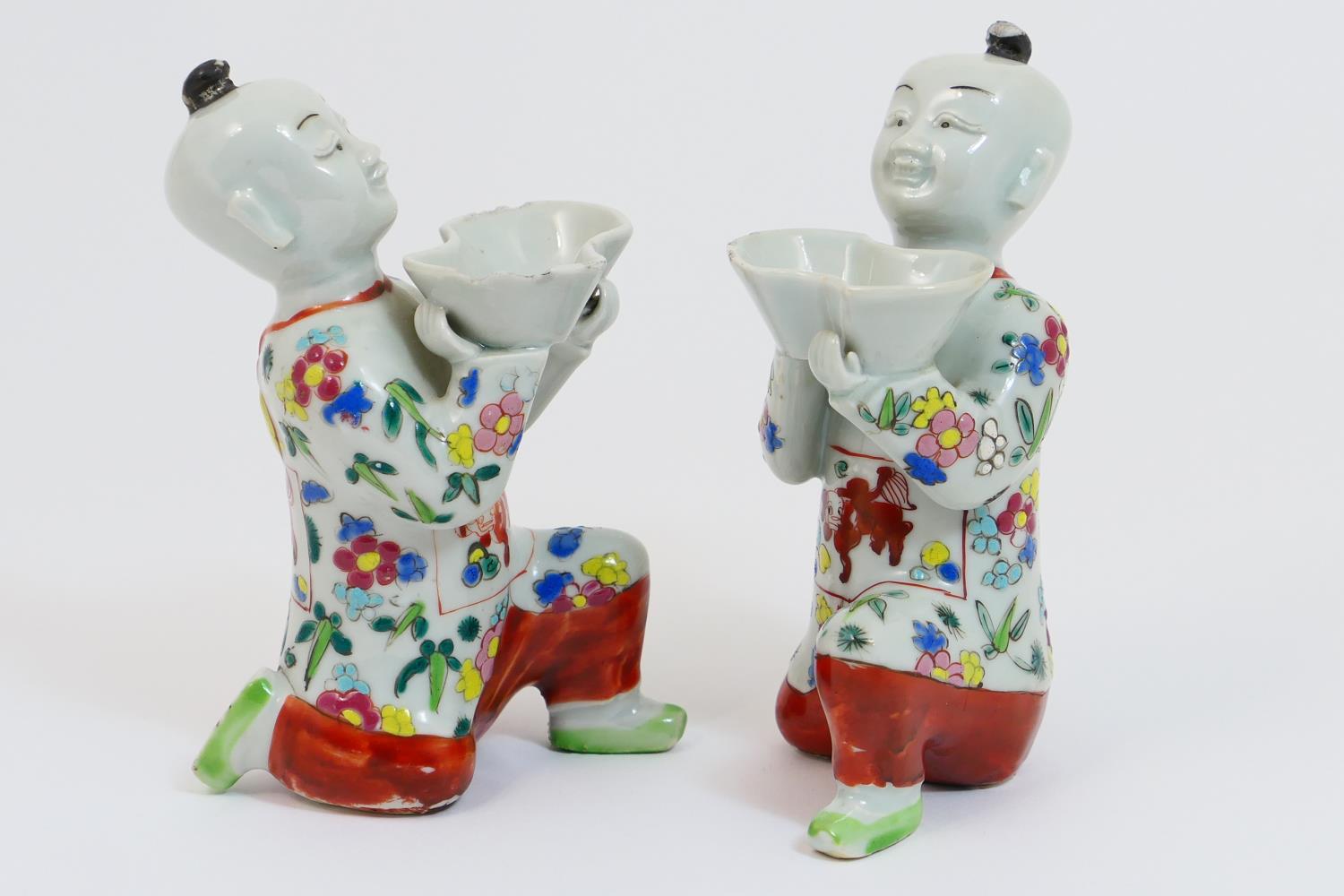 Pair of Chinese porcelain incense burners, 19th Century, modelled as boys kneeling and supporting