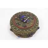 Nepalese brass filigree circular box and cover, worked with a seated deity 'jewelled' with