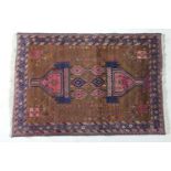 Iranian woollen rug, brown field centred with salmon pink and blue geometric reserves dispersed with