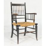 Sussex style ebonised beech armchair, circa 1900, with rail back and arms, rush seat, raised on