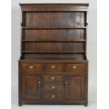 North Wales oak dresser, circa 1820, having a boarded plate rack with dentil carved cornice and