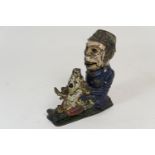 Painted cast iron novelty money box, formed as an Irishman holding a piglet, height 21cm (Viewing is