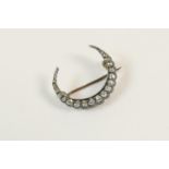 Victorian diamond crescent brooch, set with small graduating old mine cut diamonds set in silver,