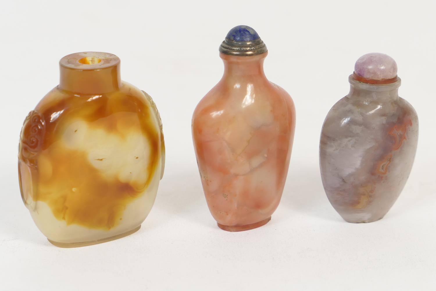 Three Chinese hardstone snuff bottles, including agate bottle with carved lion's mask ring