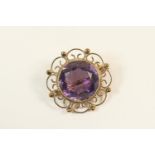 Amethyst circular brooch, the central stone approx. 15mm diameter, within a 9ct gold wirework