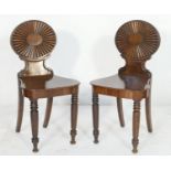 Pair of late George III mahogany hall chairs after Ince & Mayhew, each having an oval reeded fan