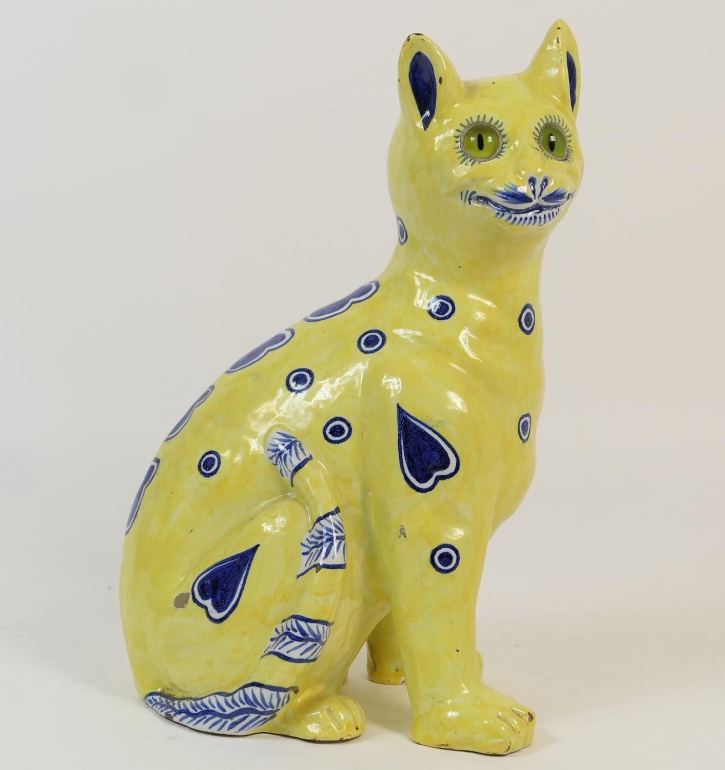 French faience pottery cat in the style of Gallé, having an allover yellow glaze punctuated with