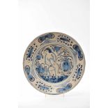 A Large DishA Large Dish, faience, blue and vinous «Aranhões» decoration "Naked female figure rising