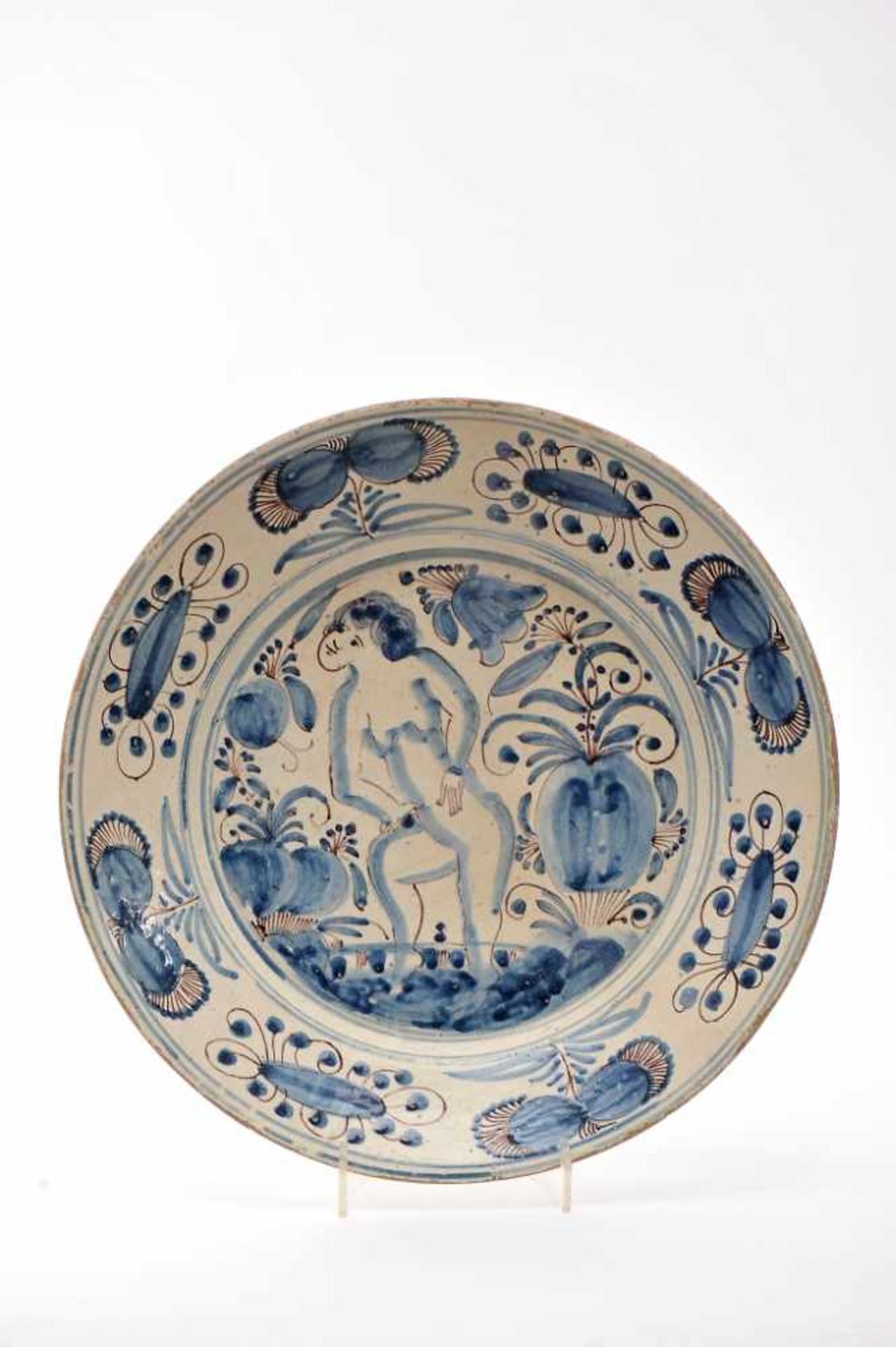 A Large DishA Large Dish, faience, blue and vinous «Aranhões» decoration "Naked female figure rising