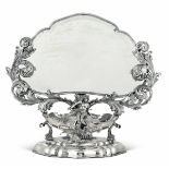 A silver mirror, 1900s, Milan - Molten, embossed and chiselled silver. 4500gr (net [...]