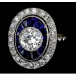 A Diamond and Sapphire Halo Ring, Modern, in 18ct white gold mount, the oval face set with a central