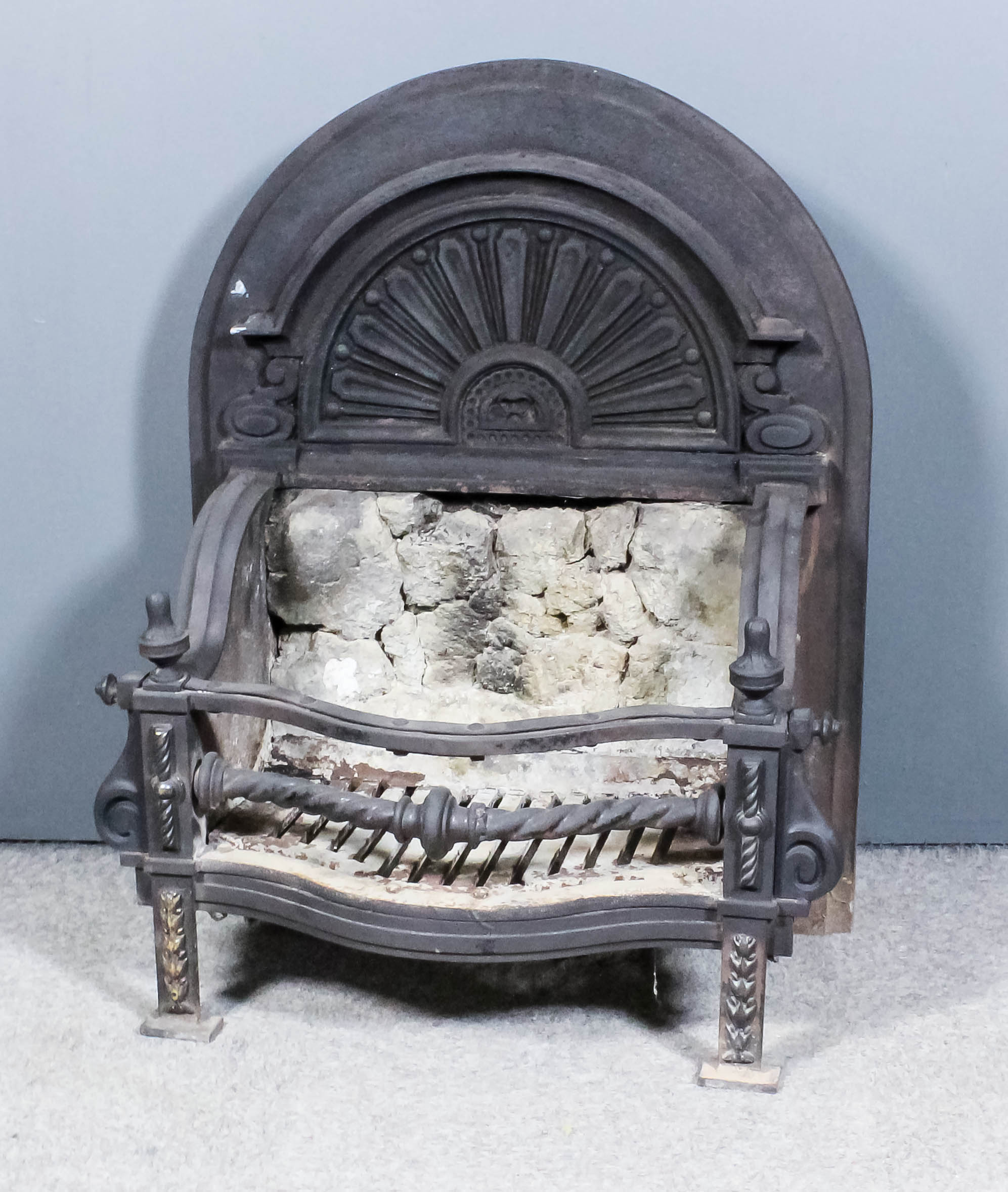 A 19th Century cast iron serpentine fronted fire grate with arched and moulded back cast with fan