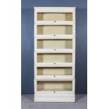 A Globe Wernicke Cream Painted Six-Tier Sectional Bookcase, each tier with a glazed rising front, on