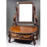 A Continental Walnut Toilet Mirror, 19th Century, carved with a ribbon and leaf design, the supports