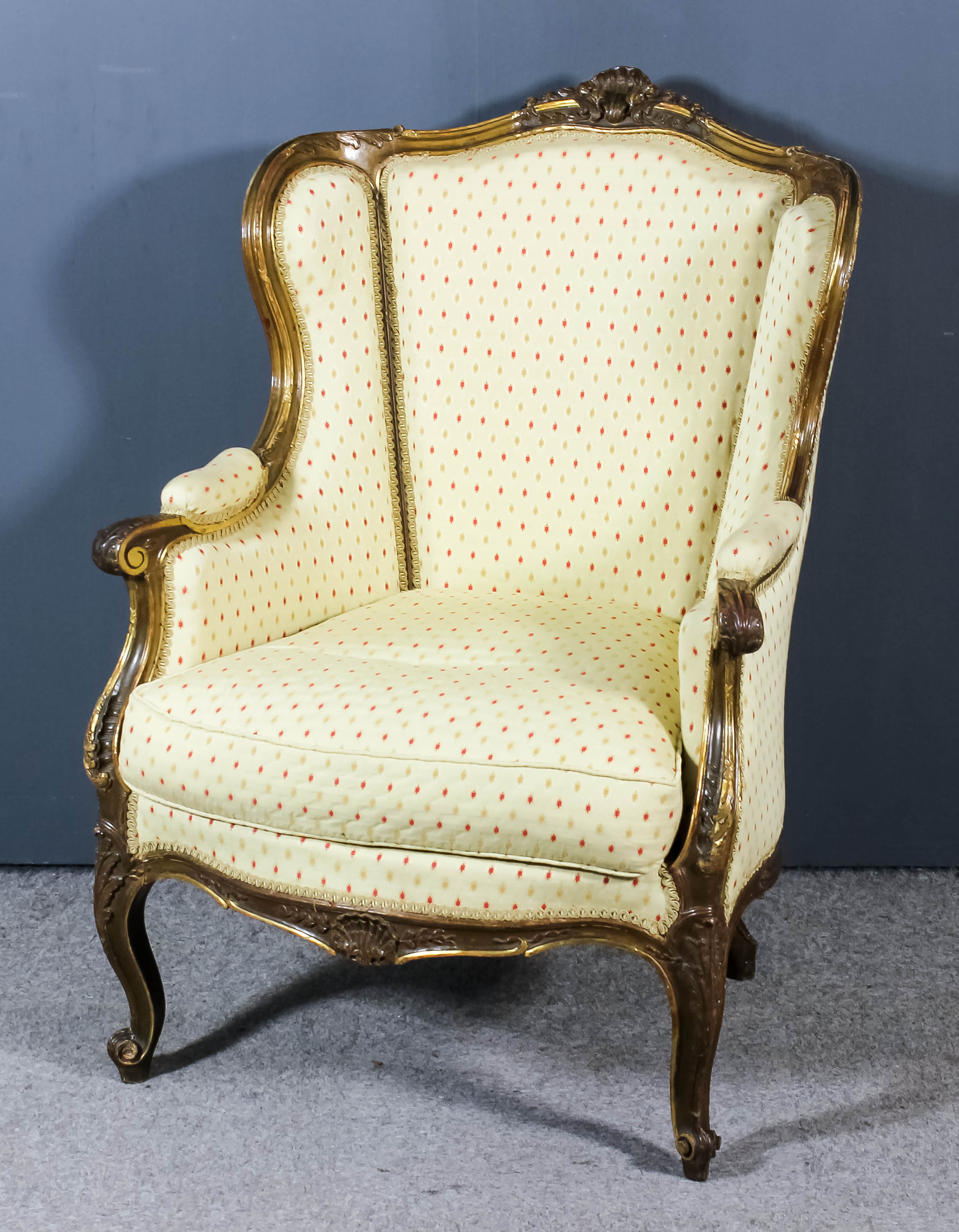 A French Gilt Framed Wingback Easy Chair, of Louis XVI design, the moulded frame with shell and leaf