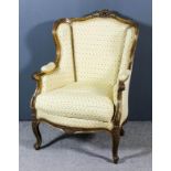 A French Gilt Framed Wingback Easy Chair, of Louis XVI design, the moulded frame with shell and leaf