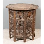 A Near Eastern Carved Wood Octagonal Occasional Table, the top carved with a band of fruiting vines,