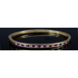 A Ruby and Diamond Stiff Bracelet, Modern, in 14ct gold mount, channel set with twelve rubies,