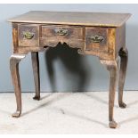 An 18th Century Oak Lowboy, with plain figured top, fitted three small drawers above shaped apron,