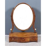 A George III Mahogany Framed Oval Toilet Mirror, on shaped uprights, serpentine fronted base