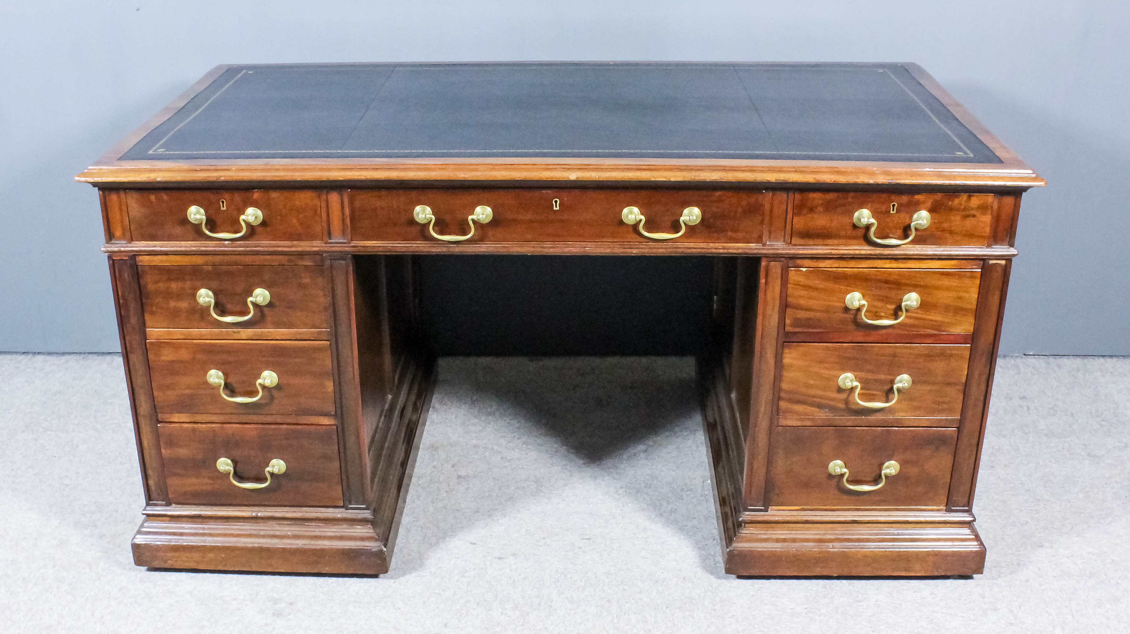 A Late Victorian Panelled Mahogany Rectangular Kneehole Desk, with tooled black leather inset to top