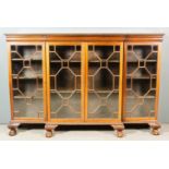 A 1920's Mahogany Breakfront Dwarf Bookcase, the top with carved leaf edge moulding, fitted eight