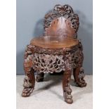 A Chinese Carved Wood Low Back Chair, the whole fretted and carved with leaves, masks, lions