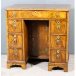 A George II Lady's Walnut Kneehole Dressing Table, the quarter veneered top inlaid with