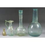 Four Roman Glass Vessels, circa 1st-4th Century AD, comprising - a glass bottle of pale green tint