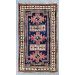 A Kazak Karachop Rug woven in colours with three angular medallions interspersed by rectangular