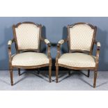A Pair of Early 20th Century French Walnut Open Arm Easy Chairs, the arched top backs carved with