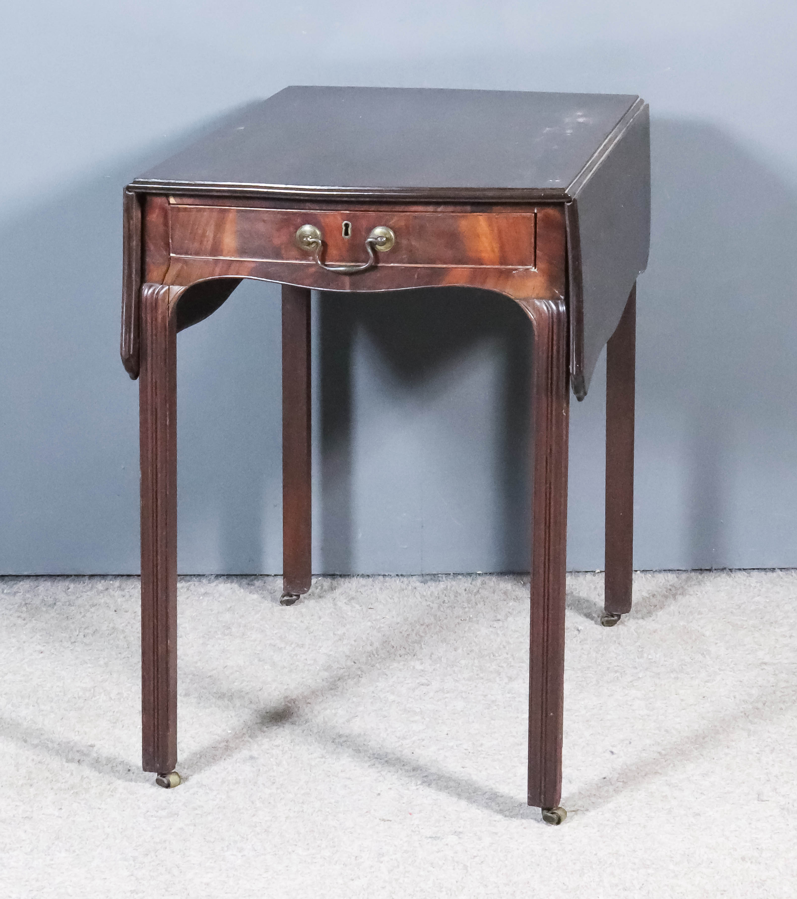 A George III Mahogany Pembroke Table, the top of serpentine outline and with moulded edge, fitted