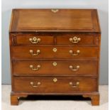 A George III Mahogany Bureau, the slope enclosing pigeon holes and eleven small drawers, fitted