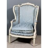 A French Off-White Painted Carved Beechwood Wingback Easy Chair of "Louis XIV" Design, the shaped