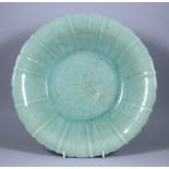 A Chinese Celadon Barbed Dish, Late Ming, the centre carved with a peony design, 12.5ins (31.8cm)