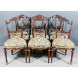 A Set of Six Late Victorian Walnut Drawing Room Chairs, the ornate shaped and moulded backs with