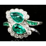 An Emerald and Diamond Ring, Modern, in platinum mount, the twin leaf pattern face set with two