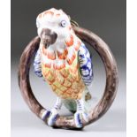 A Dutch Delft Model of a Parrot on a Ring Perch, 18th/19th Century, the moulded detail picked out in